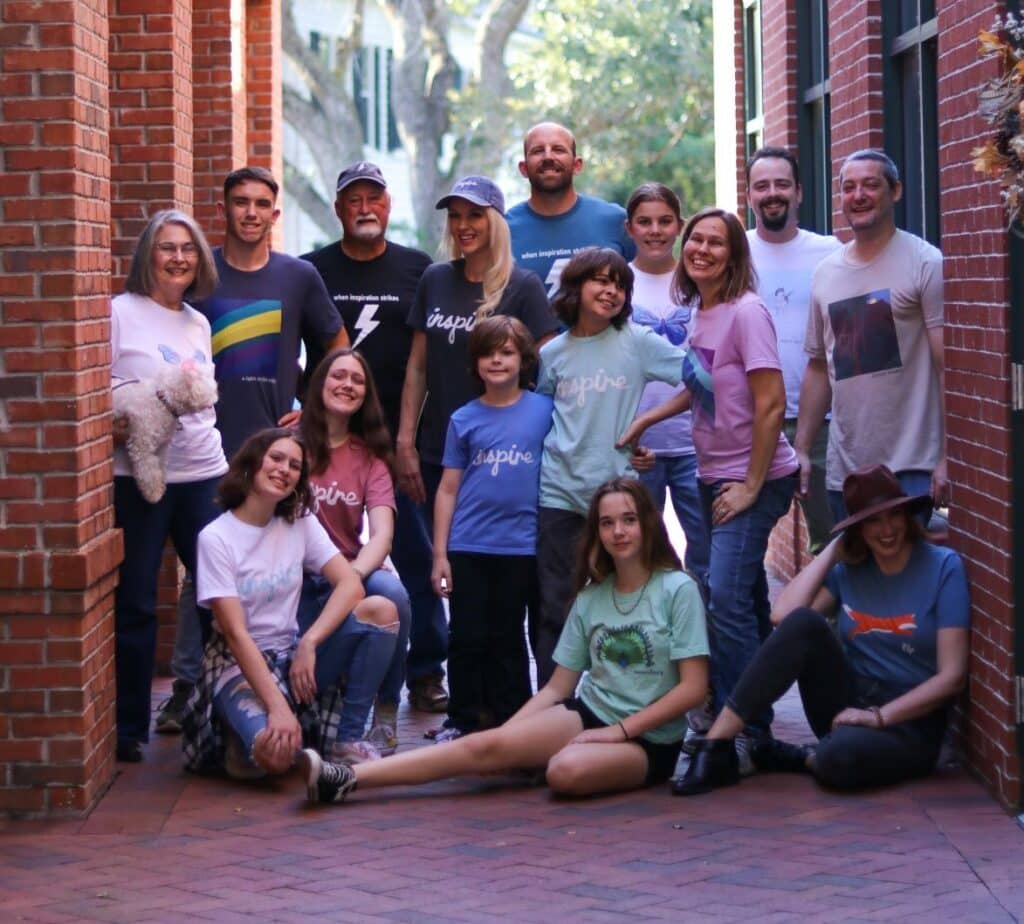 A group of people of all ages wearing positive T Shirts to Inspire Joy